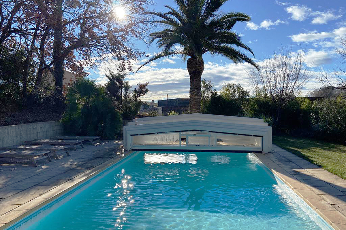 Aufnahme eines Beleuchteten Pools mit zurückgefahrener Überdachung an einem Sonnigen Tag