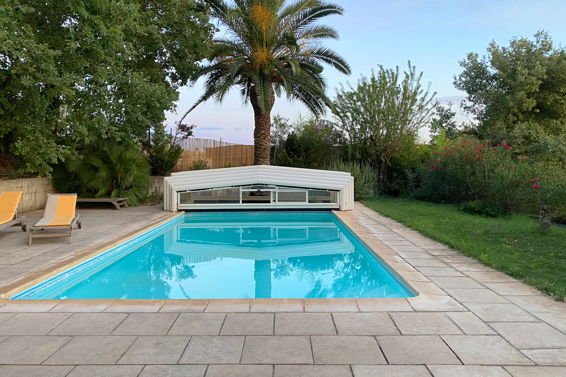 Aufnahme eines Beleuchteten Pools mit zurückgefahrener Überdachung an einem Sonnigen Tag